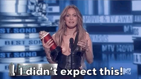 Woman holding an award saying, "I didn't expect this!"