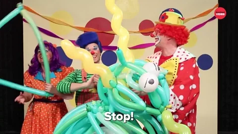 Two clowns are making balloon animals. One clown says 