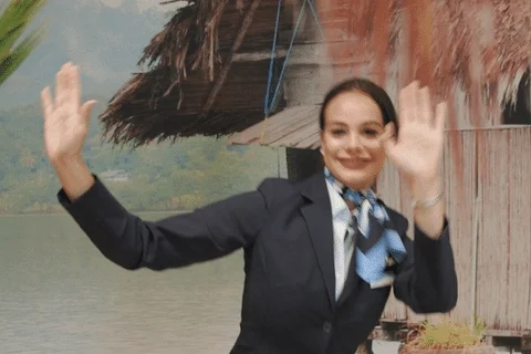 A flight attendant dancing with a smile on her face. 