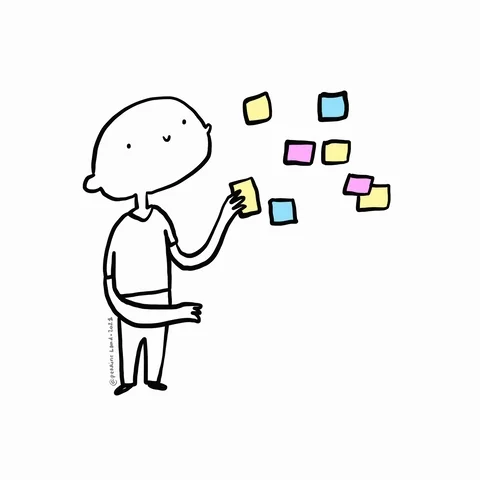 A person putting sticky notes up on a wall