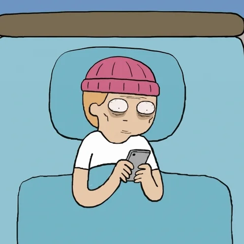 A person in bed anxiously scrolling on a phone.