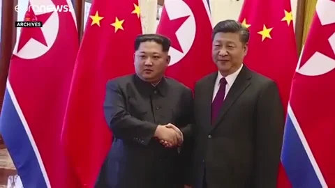 Kim Jong Un and Xi Jinping shaking hands at a press conference.