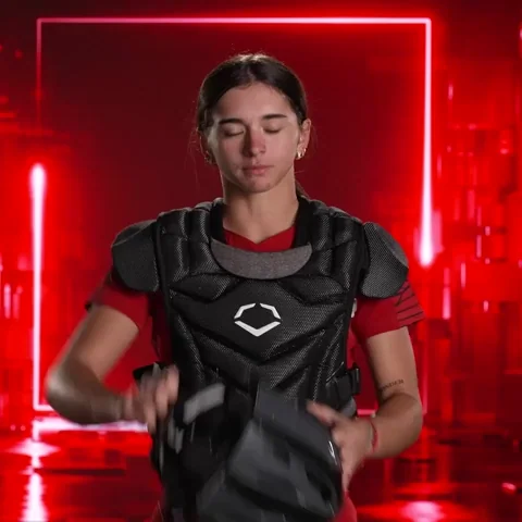 A person putting on a catcher's helmet to protect their head before playing baseball.