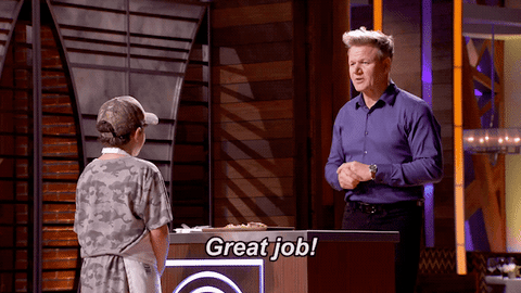 Chef Ramsey high fiving a young boy wearing an apron and a baseball cap