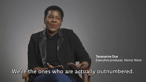 A woman sitting down saying, 