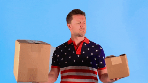 Man wearing an American flag polo and holding a box in each hand, comparing their weights