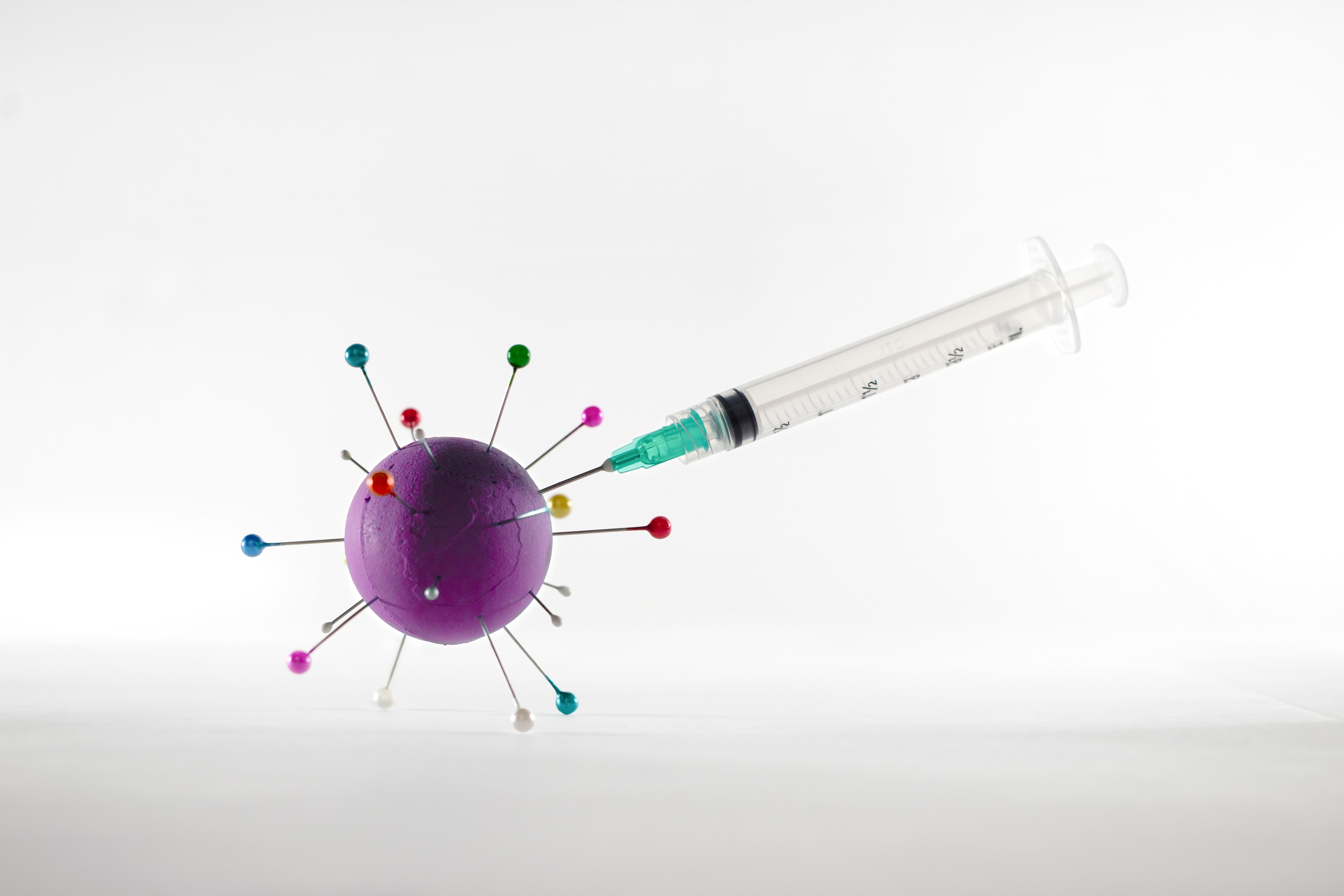 Vaccine demonstration with syringe and virus models.