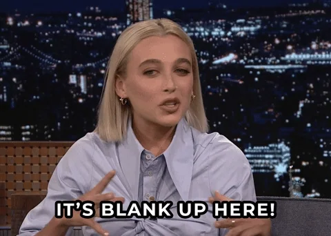 A talk show host gestures toward their head and says, 