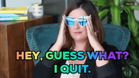 Woman sitting in chair, lowering eye glasses and winking at camera with text 'Hey, guess what? I quit.'
