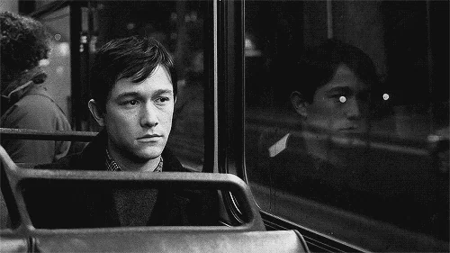 Joseph Gordon Levitt alone on a bus looking sad.