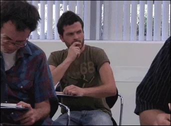 A man during a test looking ar a written note on his hand that says, 