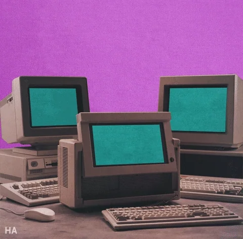 Three vintage computers displaying thumbs pixellated thumbs up, a-ok, and heart symbols.