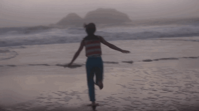 Girl running toward the ocean