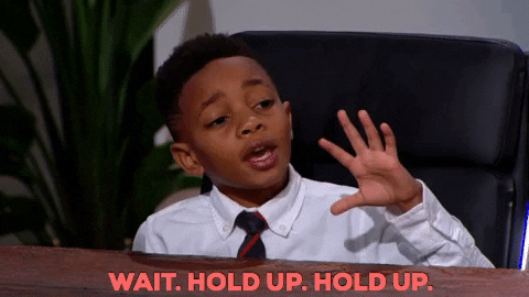 Little boy putting his hand up saying 'hold up'