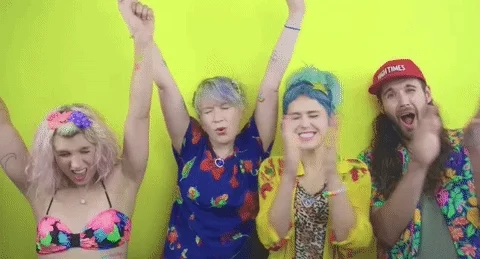 A group of young people in colorful clothing celebrating.