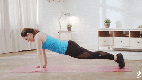 A woman doing pushups in a home office