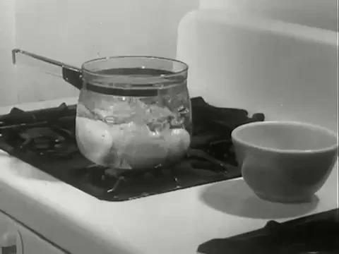  A transparent pan with eggs and water boiling in it