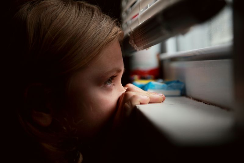 a girl peeking outside the window