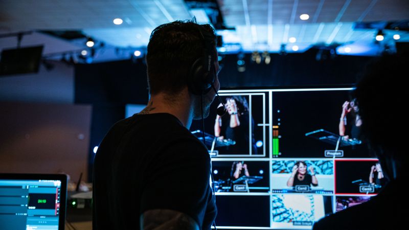 Image: Producer looks at camera screen to make sure the shoot is running smoothly.