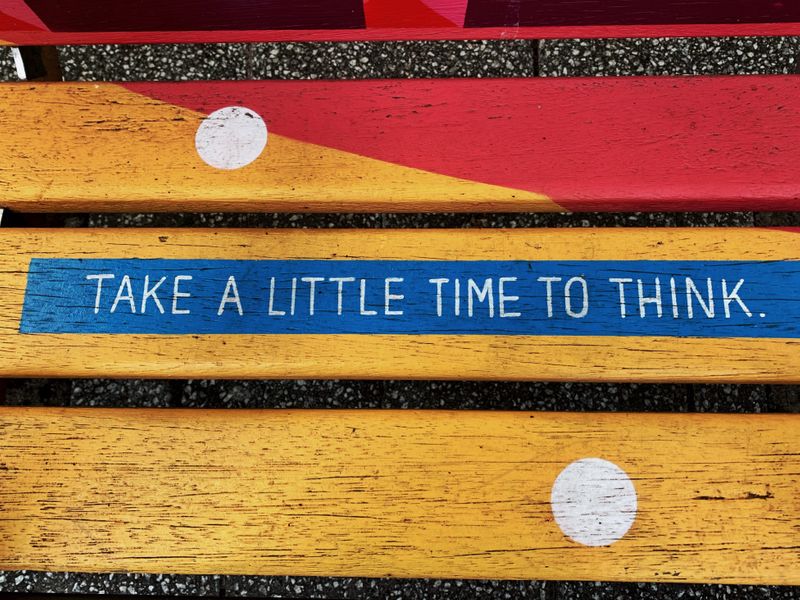 A painted sign that reads, "Take a little time to think."