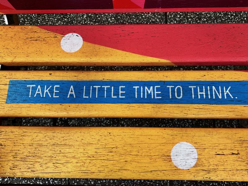 A painted sign that reads, 'Take a little time to think.'