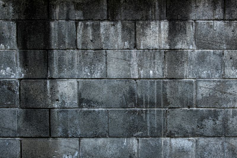 A wall made of concrete blocks with some weathering.