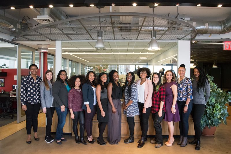 A group of women taking a picture in an office setting.