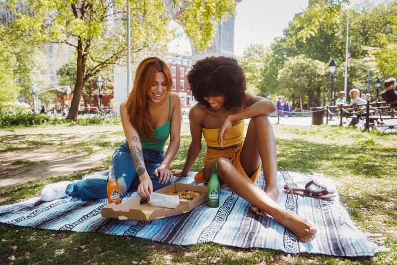 two friends laughing while having a picnic