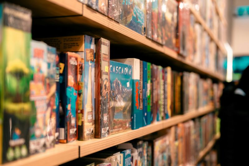 Dozens of boardgames tightly packed and arranged on rows of shelving.