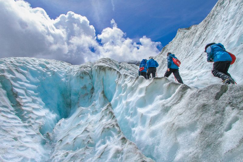 People climb a snowy mountain while supporting each other.