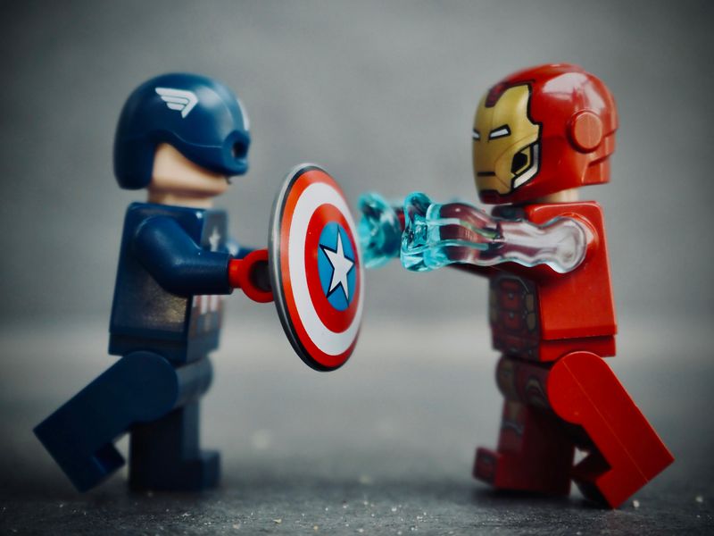 Toy figures of Captain America in blue and Iron Man in red.