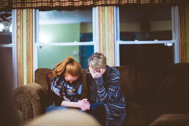 Two women consoling each other.