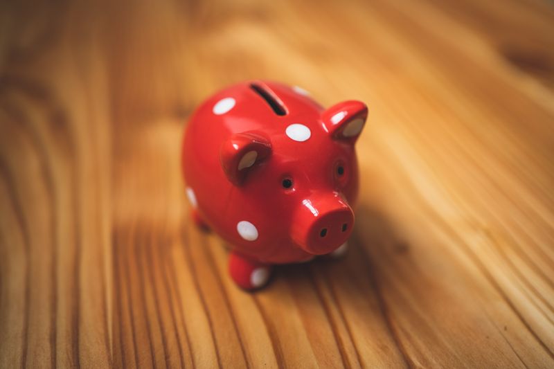 A red piggy bank on a wooden table