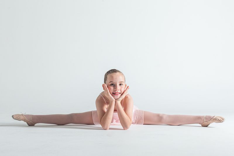 A young ballerina doing the splits.