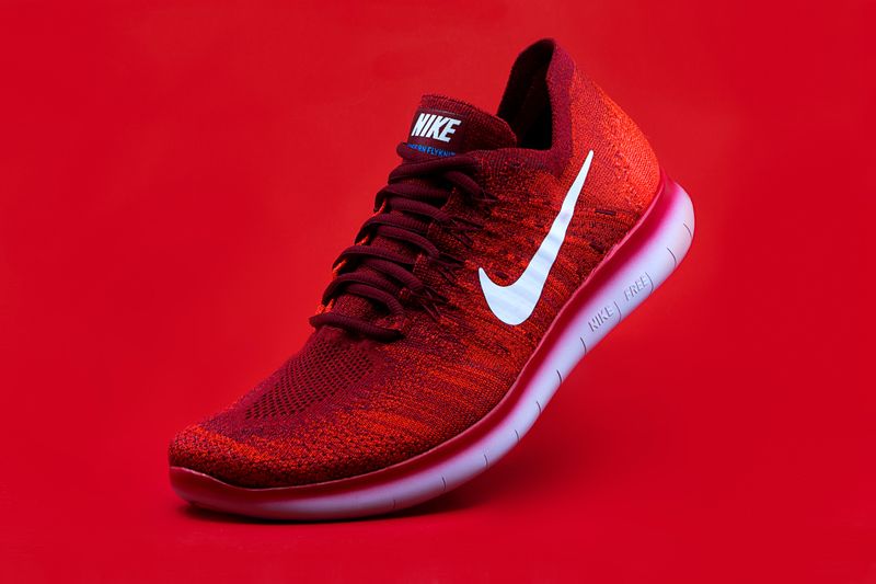 Red Nike sneaker over red background