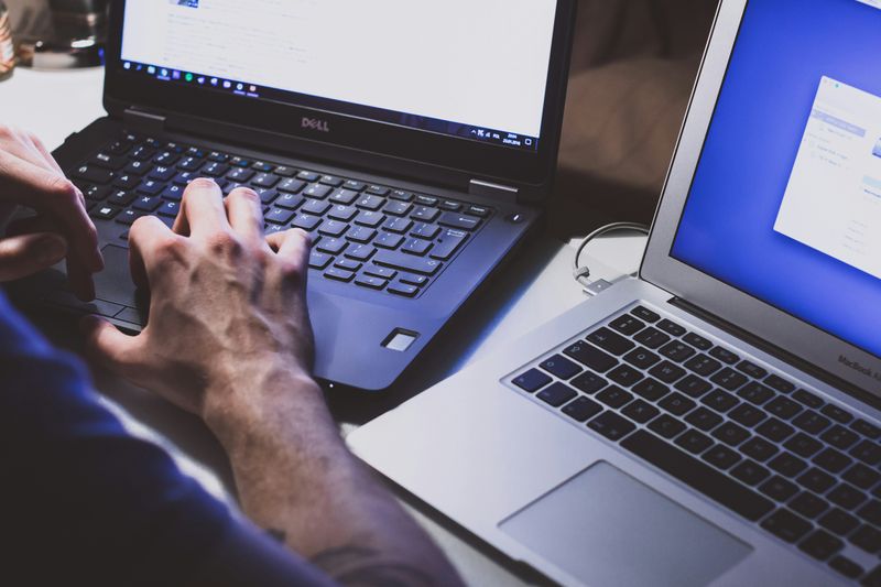 Person working with two computers 