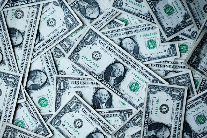 Many one dollar bills scattered on a table.