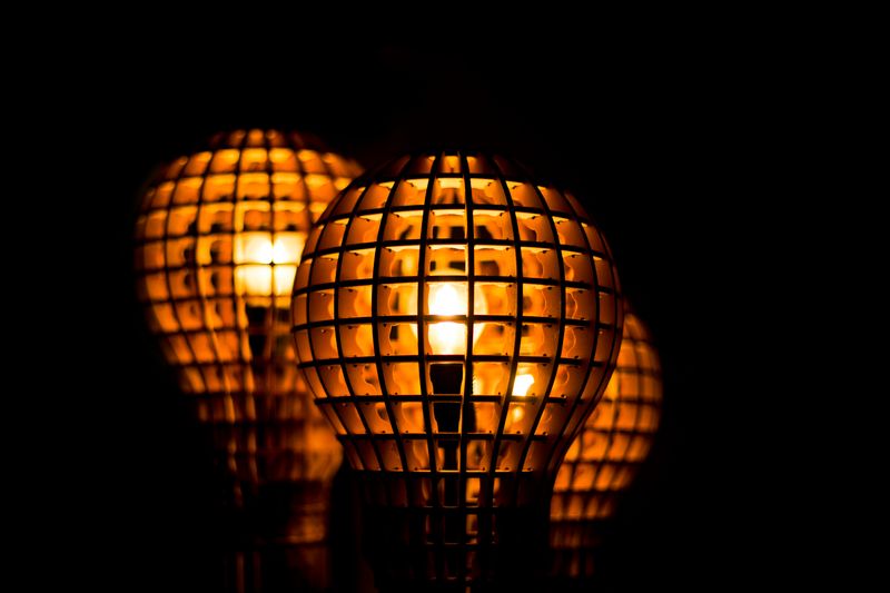 An image of three lightbulbs in cages. 