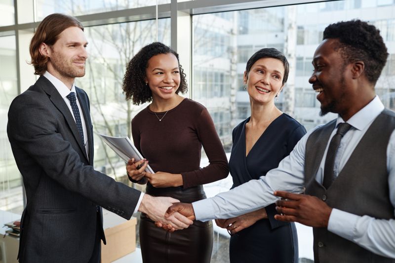 Smiling business partners shaking hands in an office.