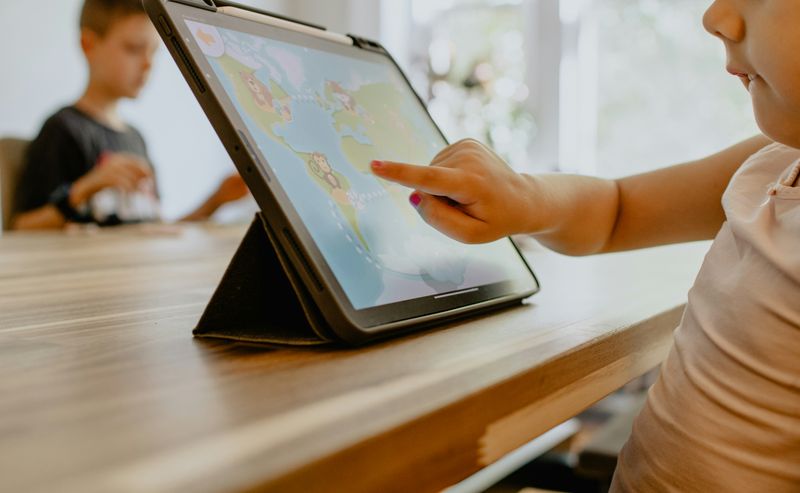 A student using a tablet computer to play a geography game for learning.