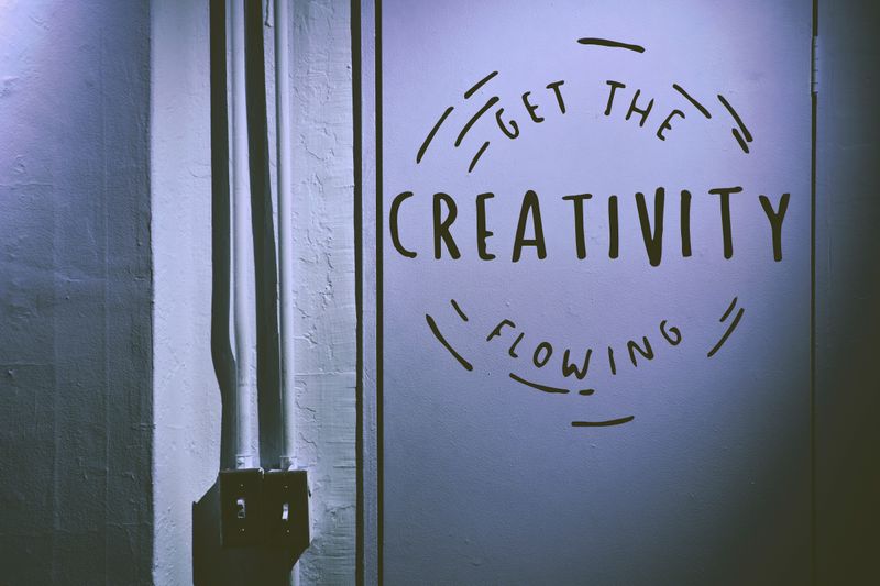 Sign on a door that says "Get the creativity flowing"