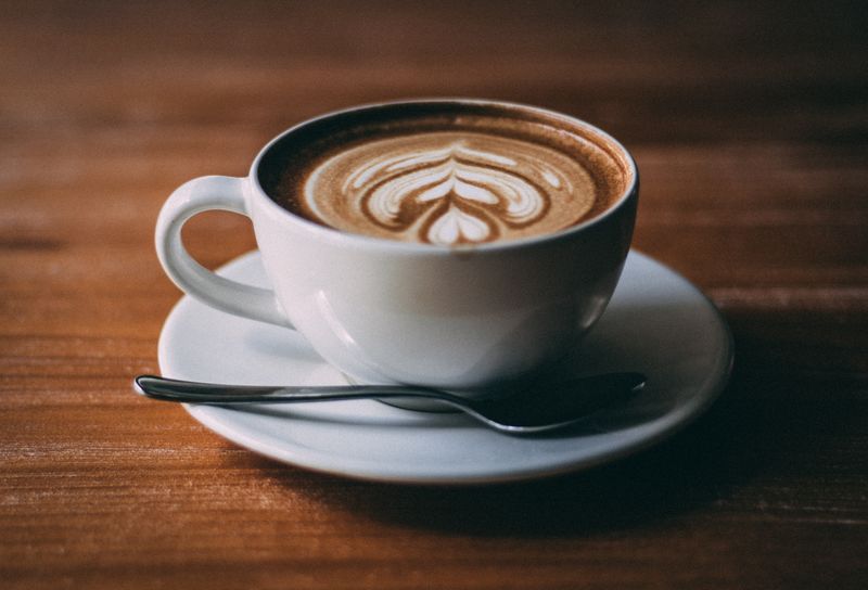 A cappuccino in a cup and saucer, served on a wooden table