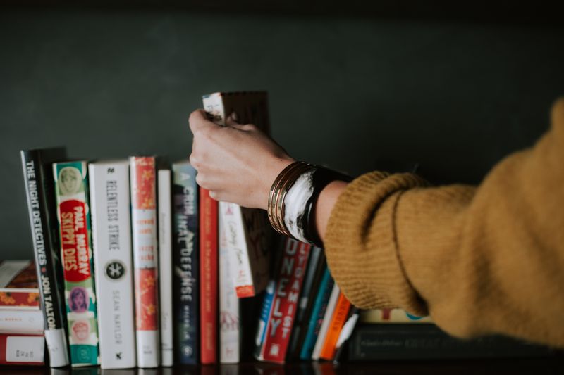 A person picking a book off a shelf.