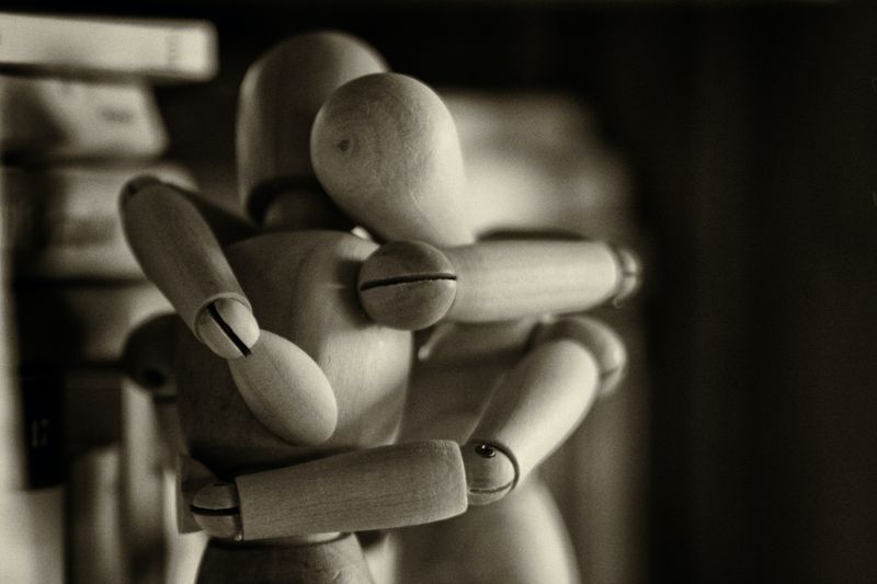 Wooden figurines hugging.