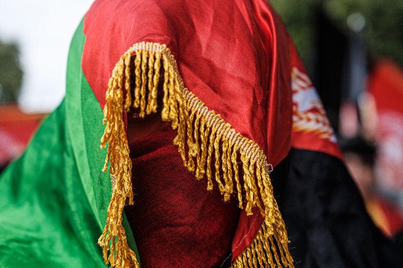 A woman draped clothing that has the colors of the Afghanistan flag.