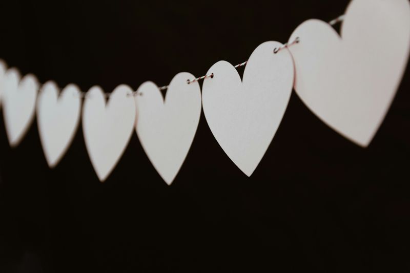 A line of paper hearts hanging on a clothing line.