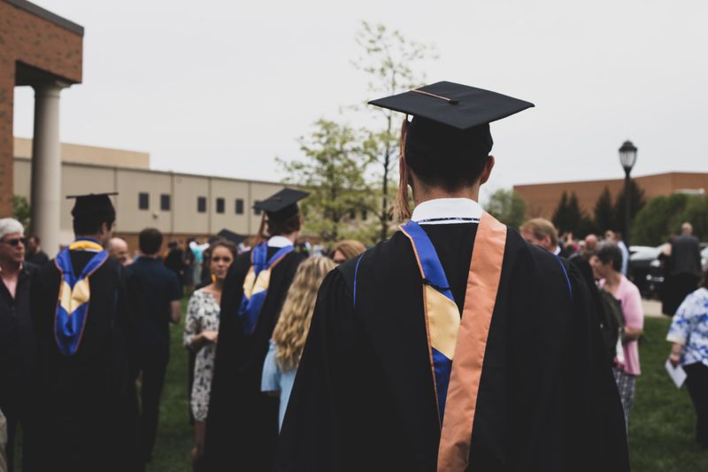 A college student at graduation wearing a cap and gown.