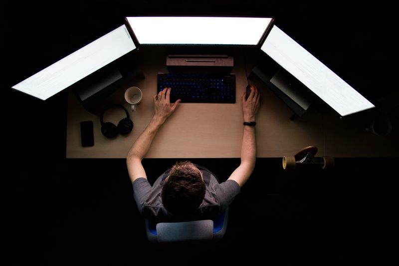 A person sitting in front of several computers