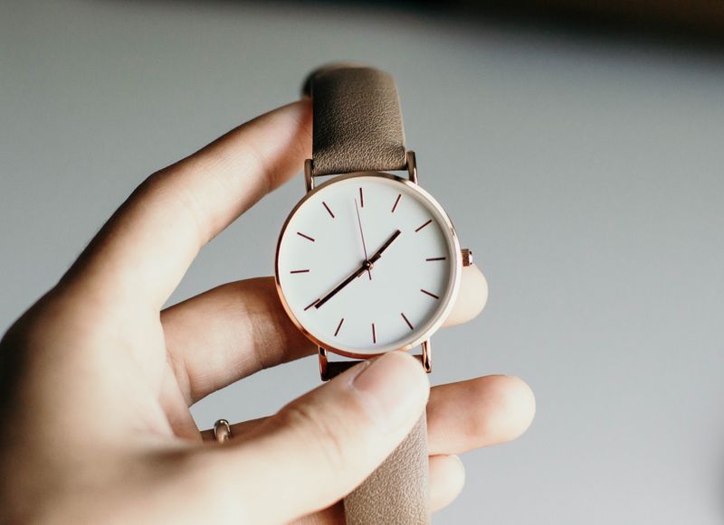 A hand holding a watch.