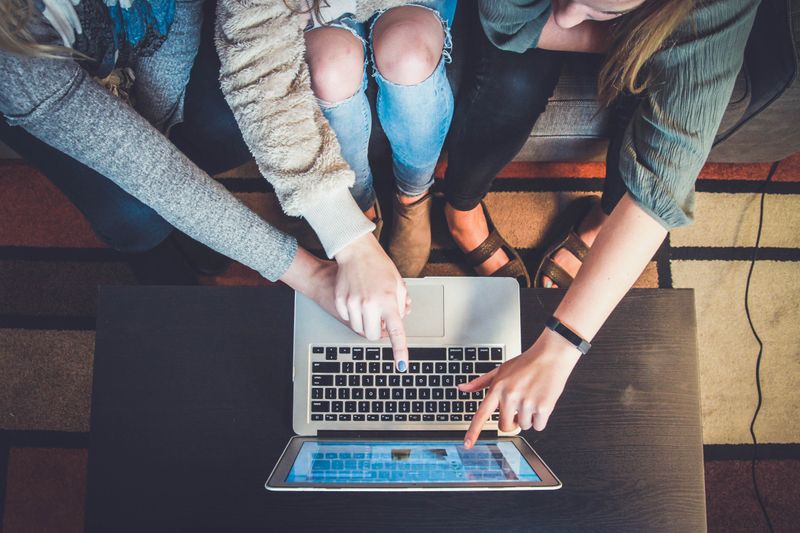 A group of students collaborating on a laptop.